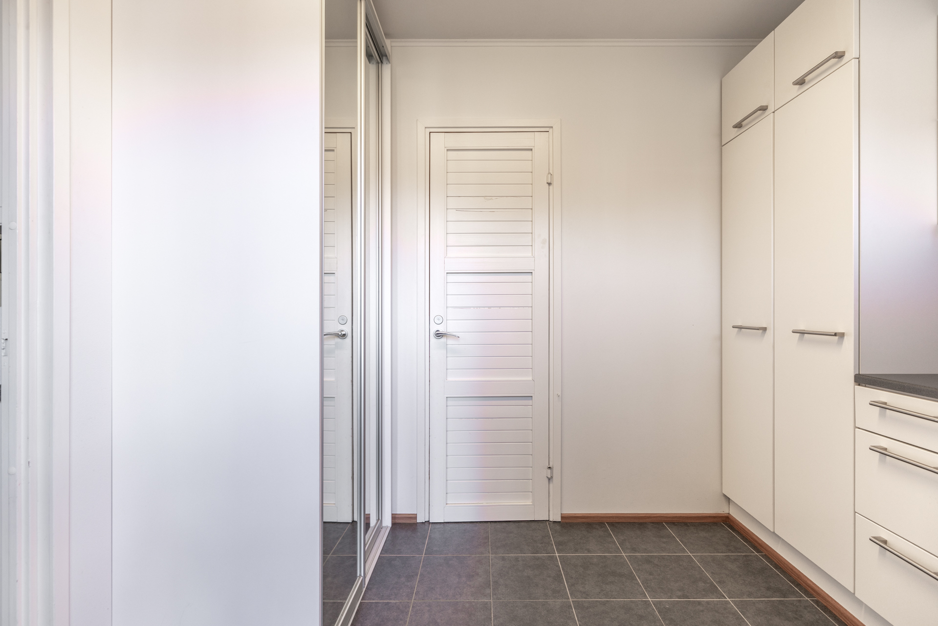 Kodinhoitohuoneessa runsaasti säilytystilaa ja käynti kylpyhuoneeseen