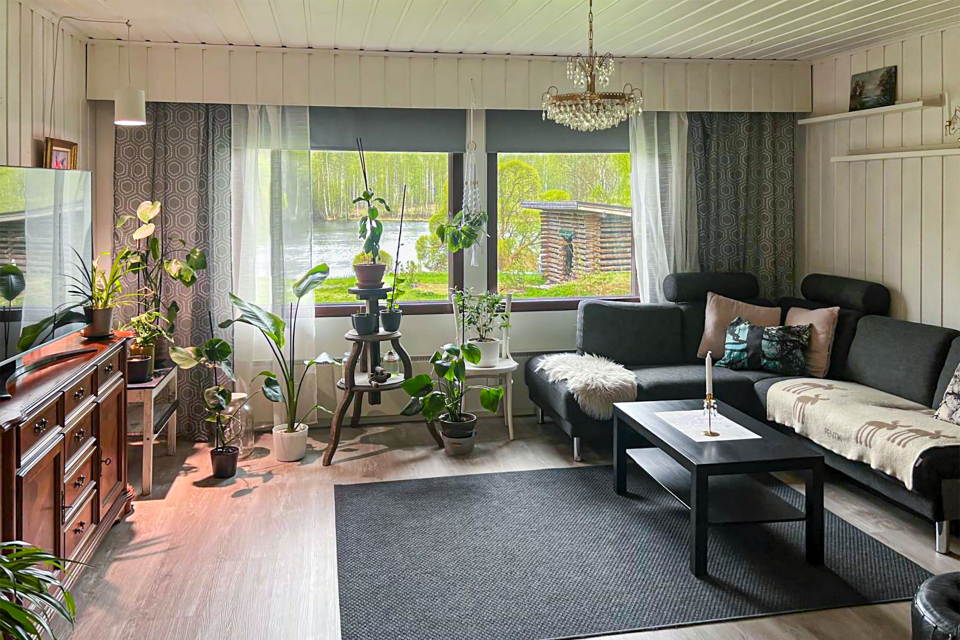 Tilava olohuone, josta näkymät rantaan lammelle.