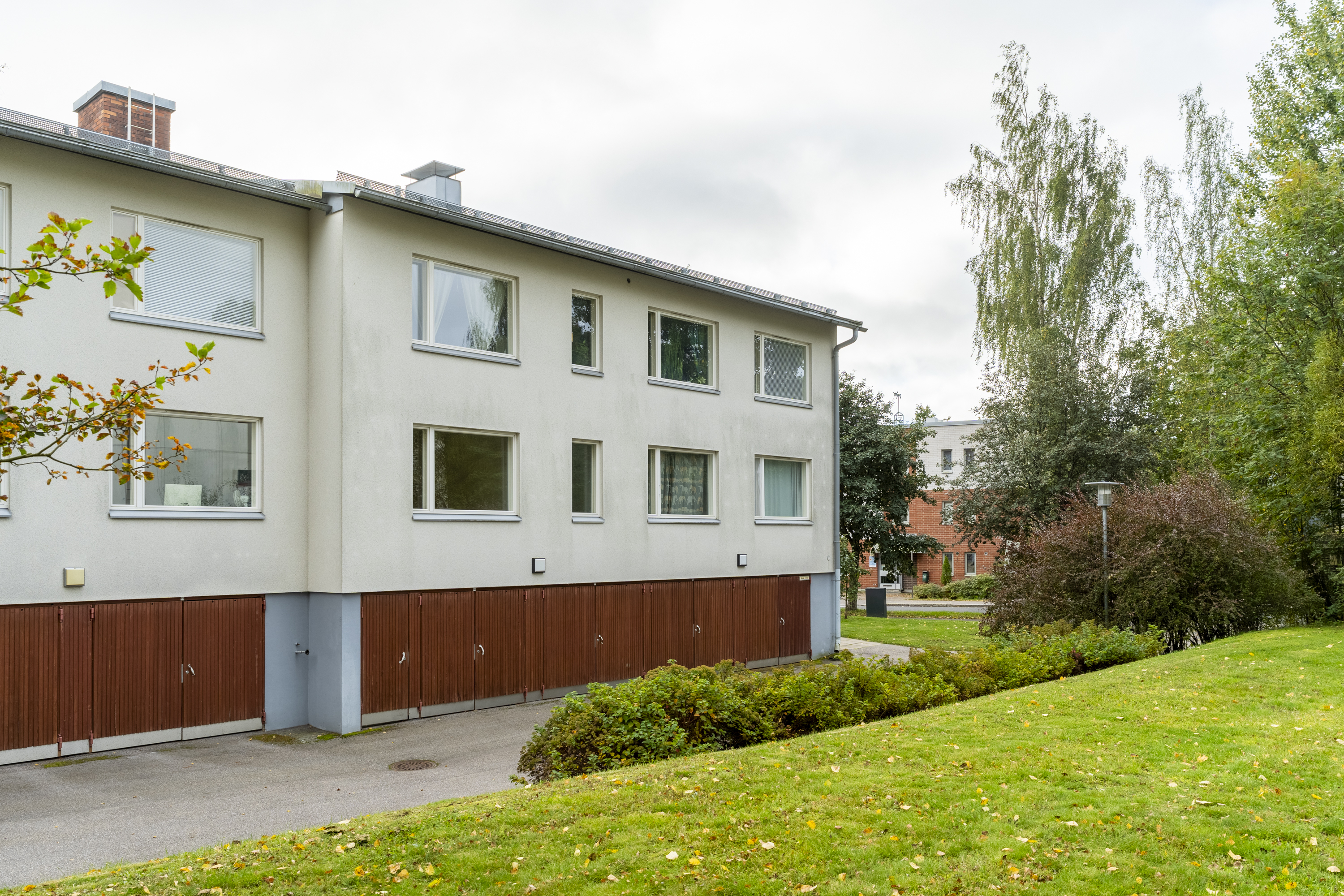 Ensimmäinen kerros on reilusti maantason yläpuolella. Autotallit alla. 