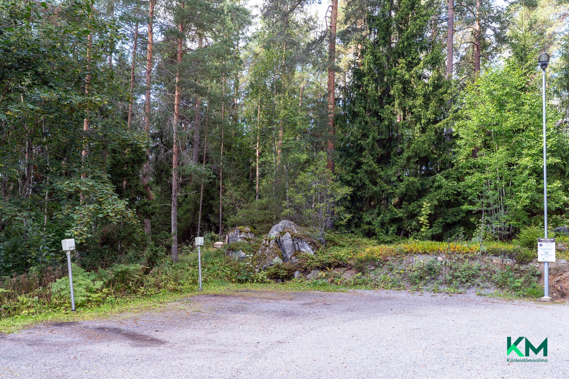 Asunnolle kuuluva pistokeautopaikka metsän reunassa
