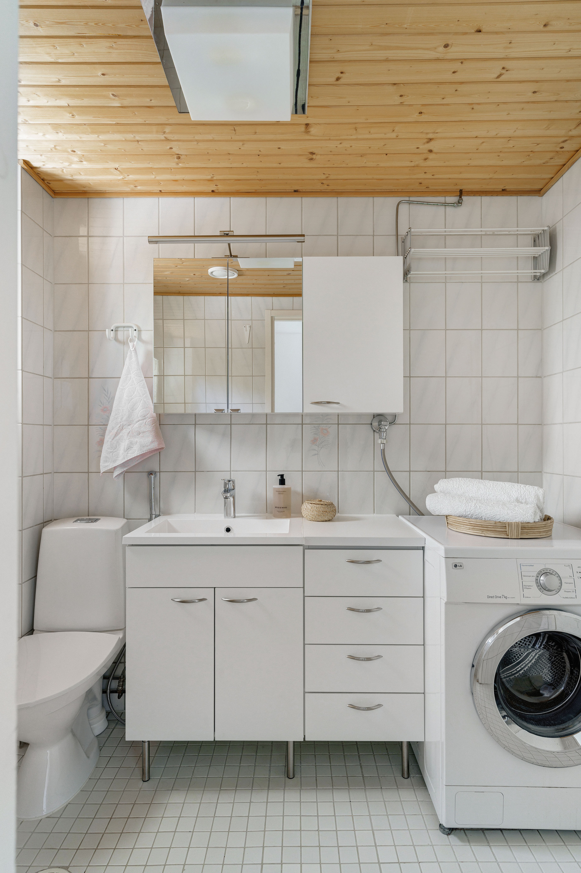 Alakerran erillinen wc, jossa mukavasti tilaa pyykkihuollolle. Oikealla varastotilaa.
