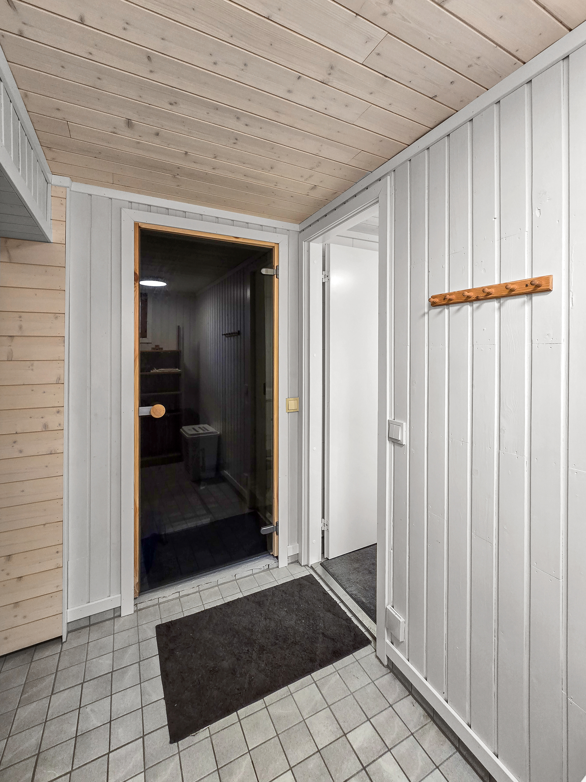 Näkymä pukeutumistilasta: oikealla kylpyhuone, edessä sauna.