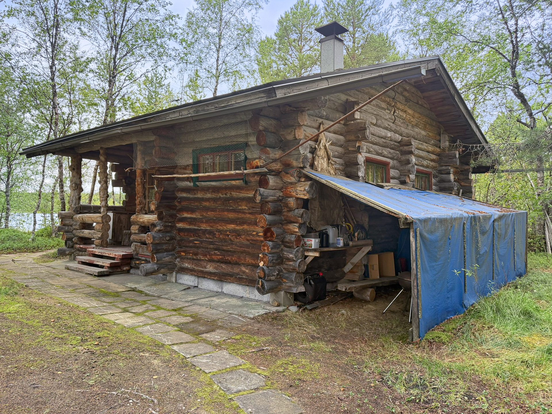 Päämökki, seinustalla purkukuntoinen katos