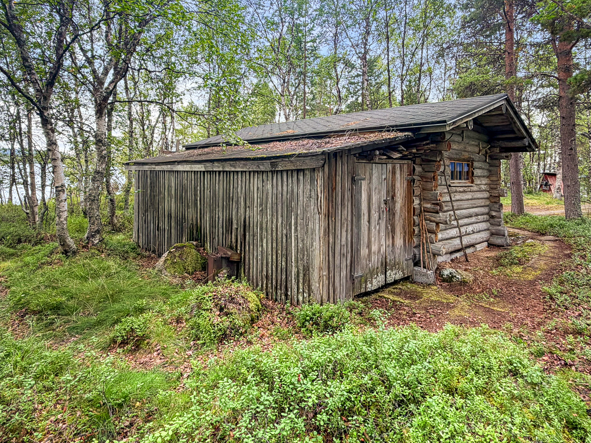 Varastorakennuksen takana vanha, purkukuntoinen kelkkavaja