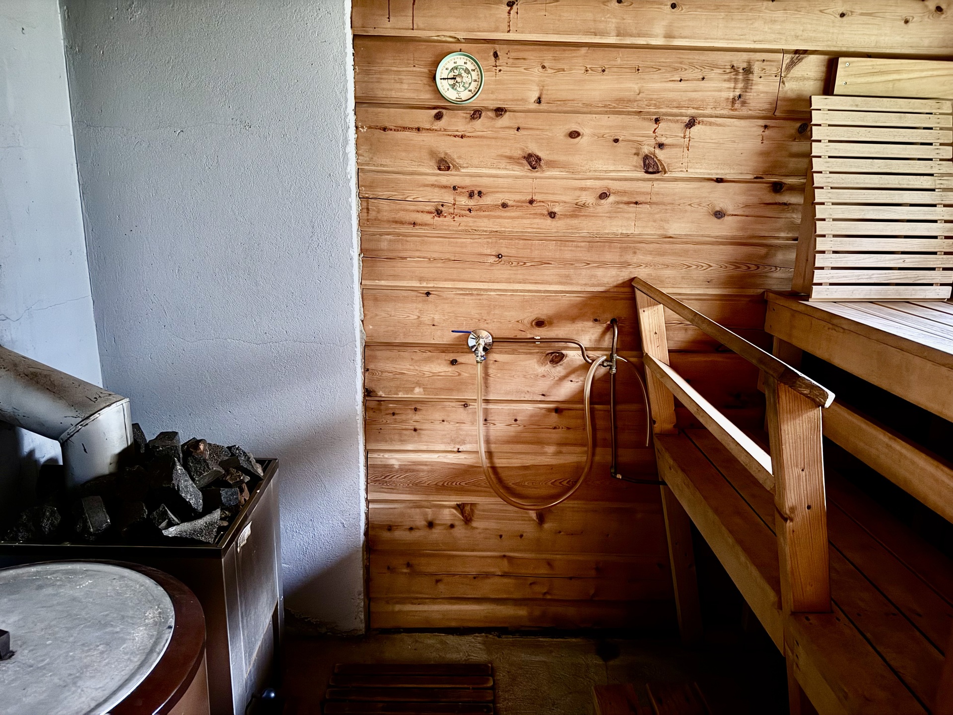 Saunassa puulämmitteinen kiuas ja erillinen pata veden lämmitykseen