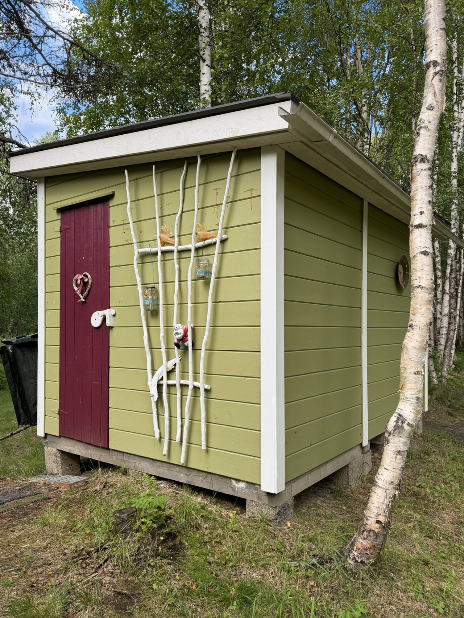 Kaksiosainen ulkovarasto. Toisella puolella varastointitilaa, toisella puolella puuhahuone.