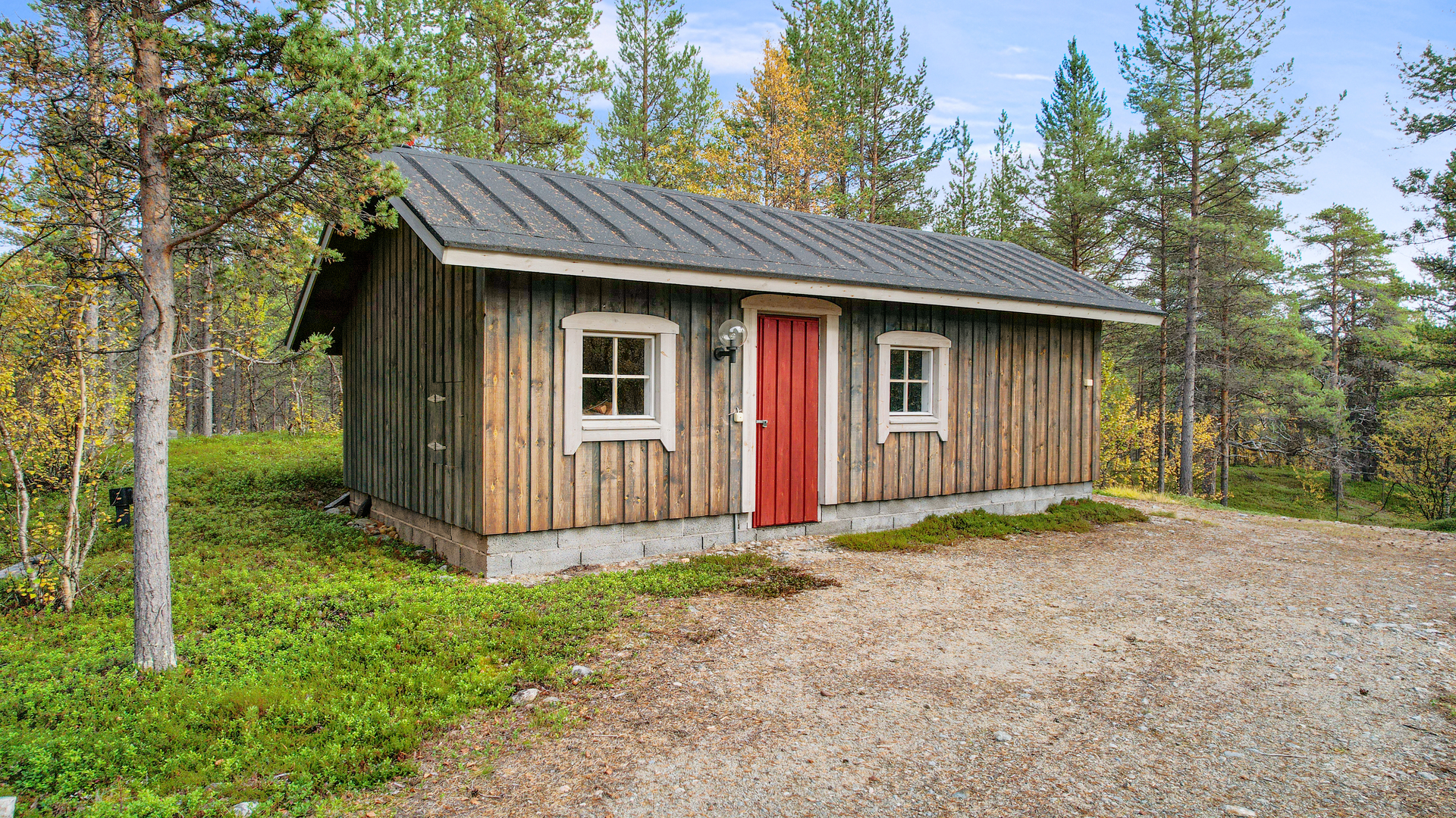 Talousrakennus, jossa autotallin lisäksi puuliiteri ja ulko-wc.