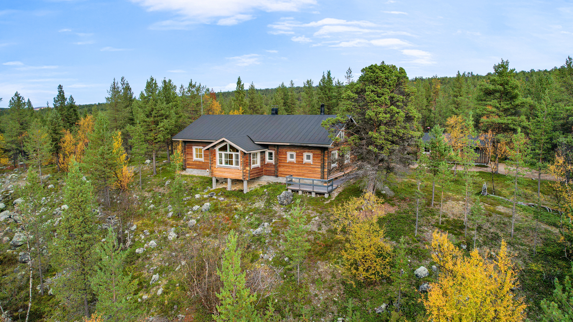 Päärakennus korkealla jokitörmällä.