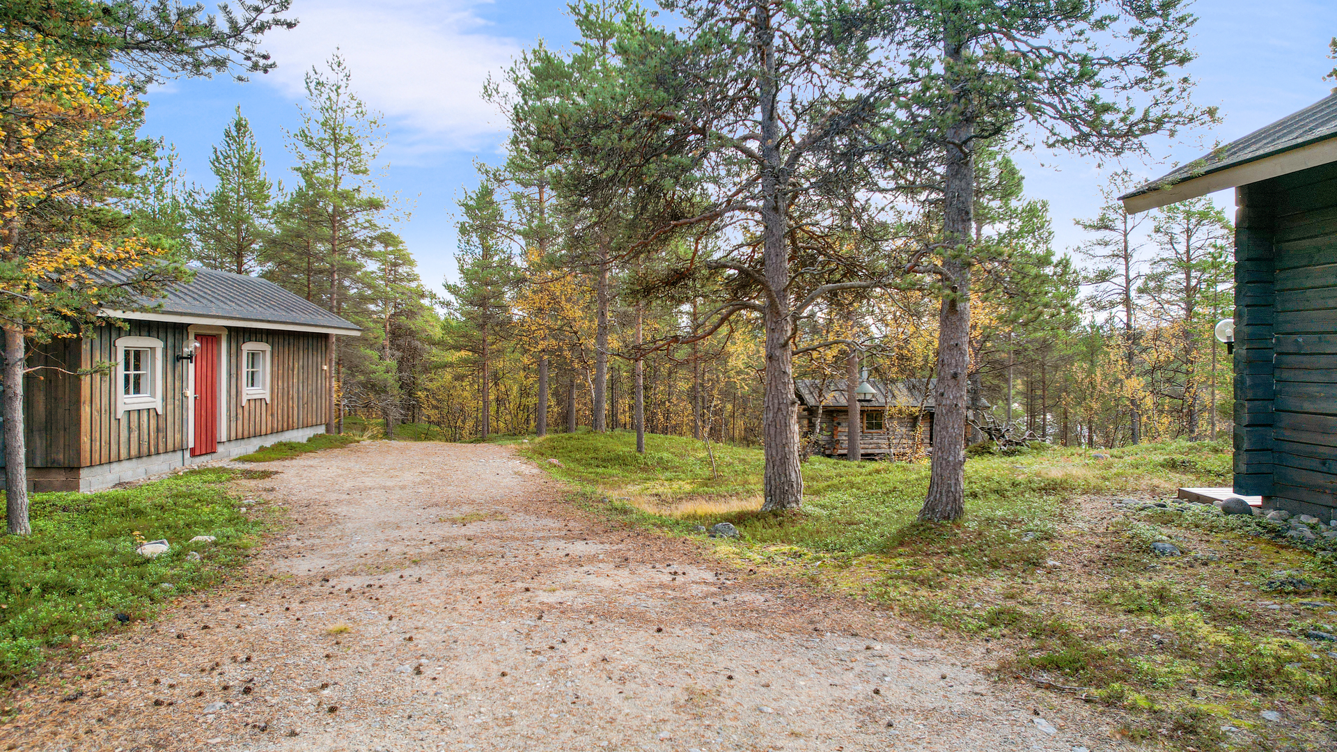 Näkymä etupihalta kohti talous- ja saunarakennusta.