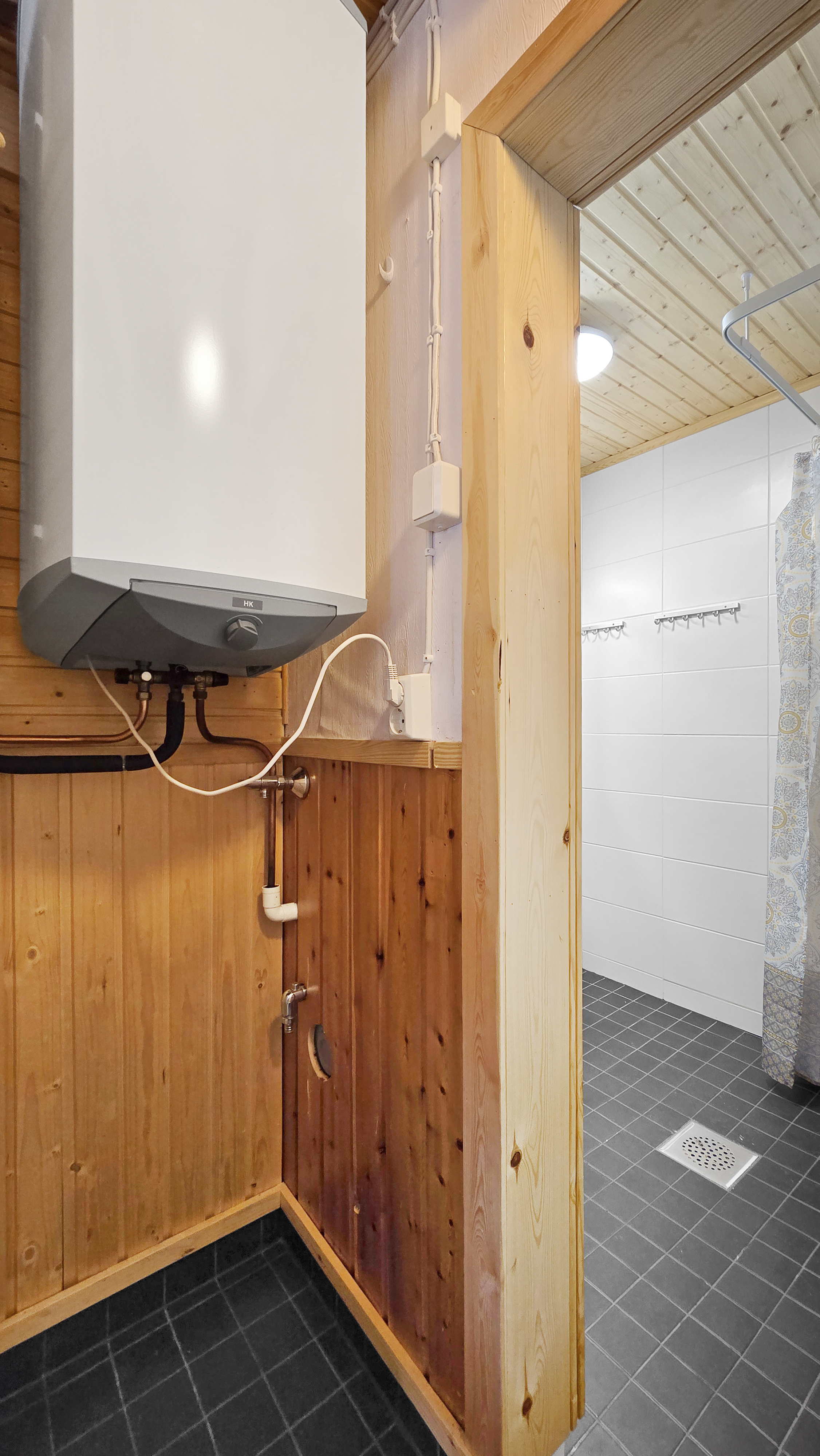 Kylpyhuone/wc:n yhteydessä lämminvesivaraaja ja paikka pyykinpesukoneelle