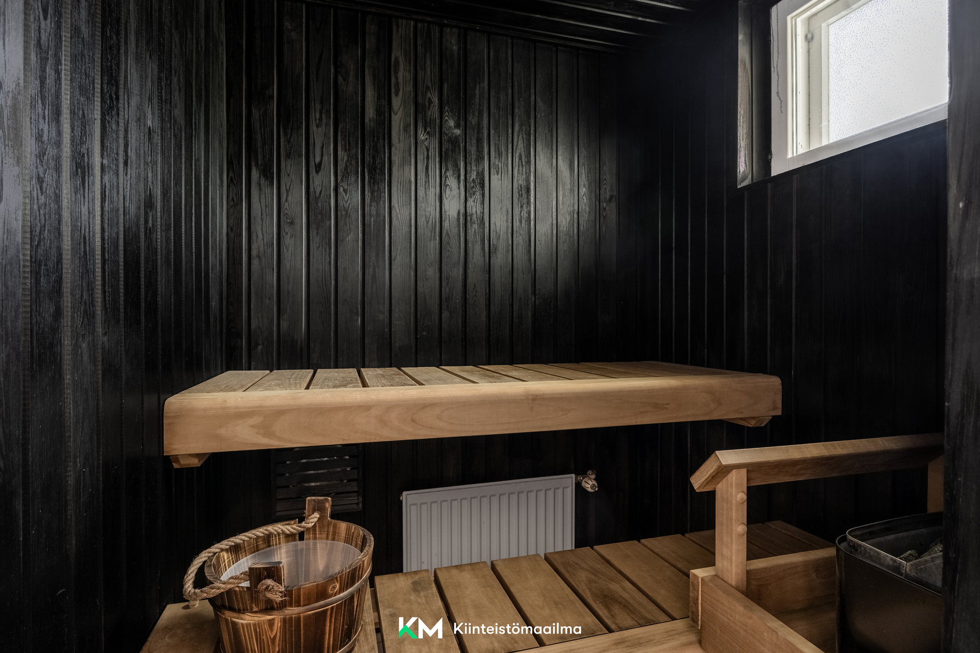 Ikkunallinen sauna on tunnelmallinen tummine seinineen